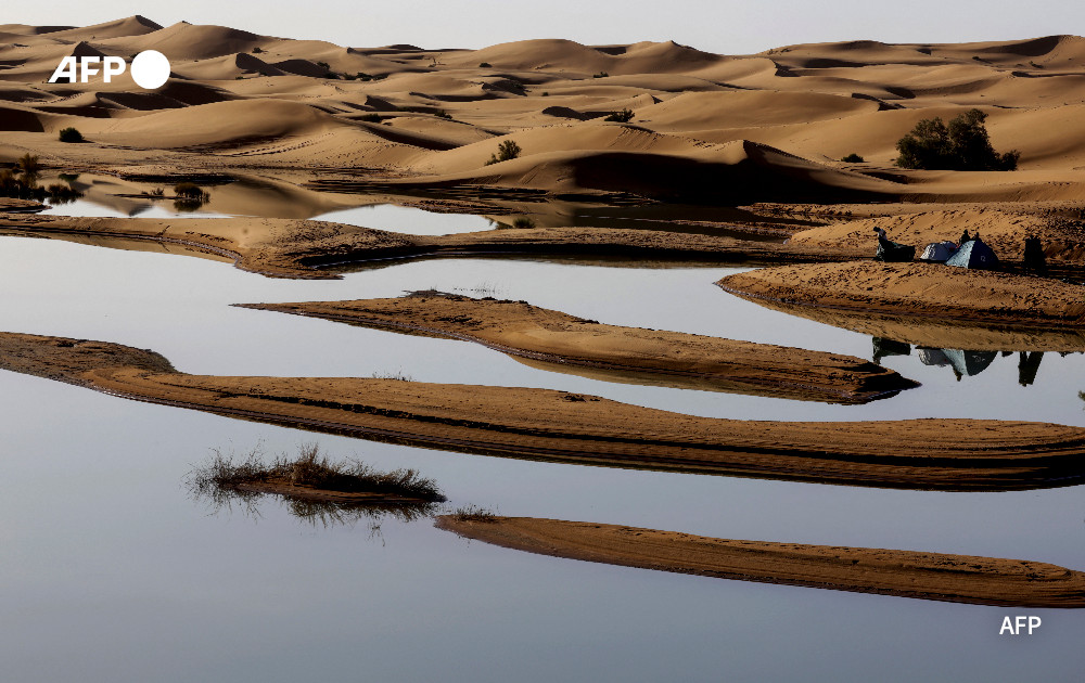 Tourists camp on the shores of Erg Znaigui, a seasonal lake in the village of Merzouga in the Sahara desert in southeastern Morocco on October 20, 2024.