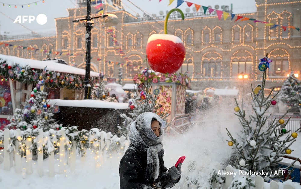Woman walks in christmas market, in the snow