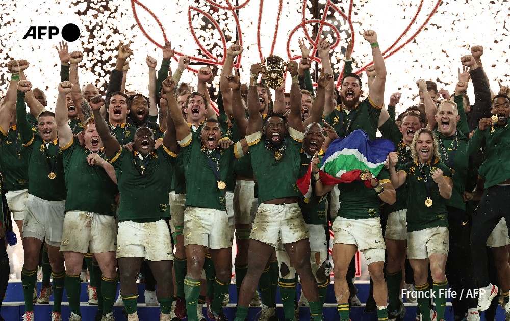 South Africa's flanker and captain Siya Kolisi (C) lifts the Webb Ellis Cup as South Africa's players celebrate winning the France 2023 Rugby World Cup final 
