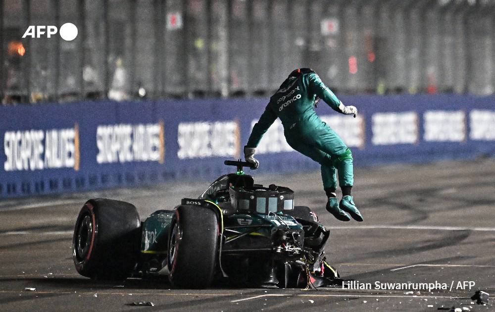 F1 driver Lance Stroll jumping out of his car after crashing