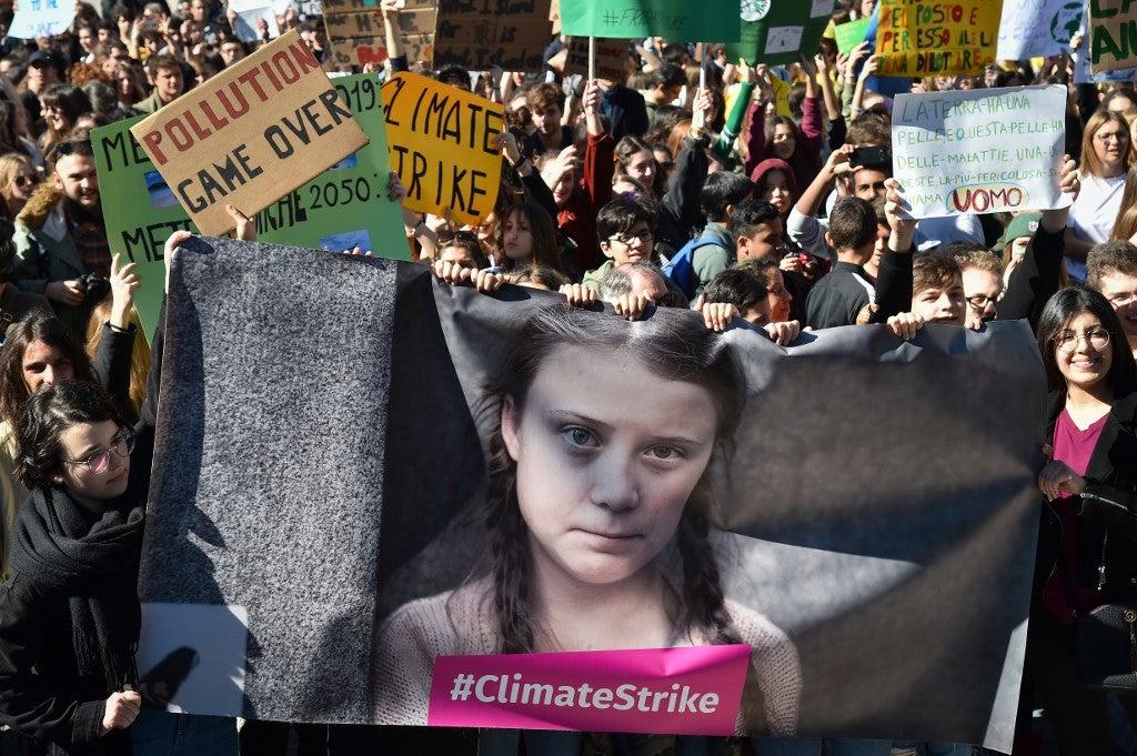 Personas y estudiantes sostienen carteles y pancartas que muestran a la activista política sueca Greta Thunberg, de 16 años, en protesta contra el calentamiento global en el centro de Roma, el 15 de marzo de 2019. Andreas SOLARO / AFP