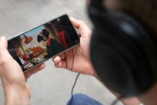 Un homme regarde sur son téléphone la chaîne YouTube "LoFi Girl", produite par le Français Dim et illustrée par Juan Pablo Machado, le 17 septembre 2026 à Paris — Kenzo TRIBOUILLARD / AFP