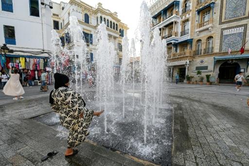 Une femme se rafraîchit à une fontaine lors d'une vauge de chaleur en Tunisie, le 24 août 2026 à Tunis — FETHI BELAID / AFP