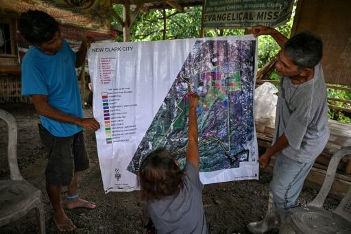 Residents look at a map with proposed projects by the Bases Conversion and Development Authority (BCDA) in Capas, Tarlac province — Jam STA ROSA / AFP