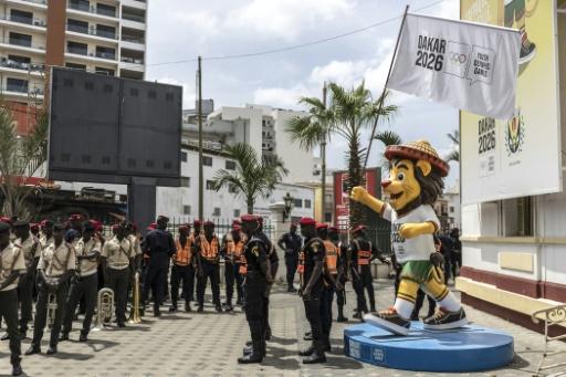 Police stand in formation next to a statue of Ayo, Senegal’s Youth Olympics Games mascot — PATRICK MEINHARDT / AFP