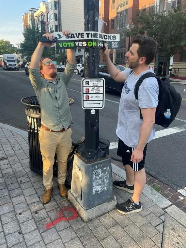 Mike Accardi (L) and James Nance (R), put up signs in Washington DC to raise awareness of the November ballot measure — Matthew PENNINGTON / AFP