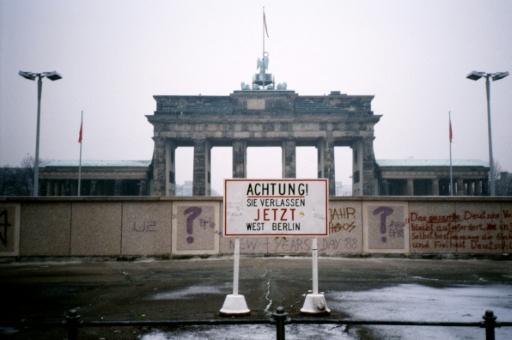 El Muro de Berlín y la Puerta de Brandeburgo, en una imagen de 1988. El letrero advierte: "¡Atención! Está saliendo de Berlín Occidental" — Jean-Philippe LACOUR / AFP