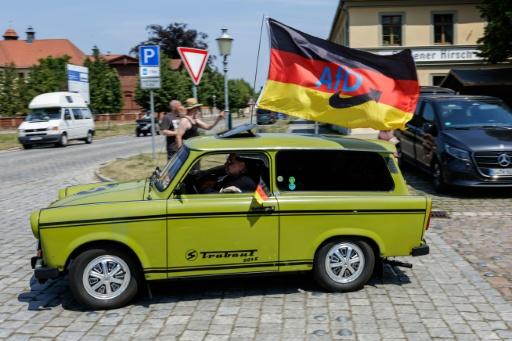 Un simpatizante de la AfD conduce un auto Trabant fabricado en Alemania Oriental y lleva una bandera alemana con el logotipo del partido de extrema derecha — Jens SCHLÜTER / AFP