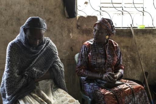 Aminata Boye (R) visits with another woman at her home in Mbour, Senegal — PATRICK MEINHARDT / AFP