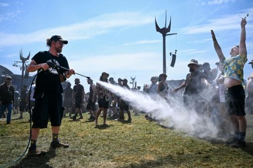 Un membre de l'organisation du Hellfest asperge d'eau des festivaliers durant une vague de chaleur lors de la 19e édition de ce festival de heavy metal à Clisson, en Loire-Atlantique, le 19 juin 2026 — Sebastien Salom-Gomis / AFP