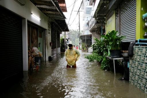 A person tends to their flooded shop in the Bang Bua district of Bangkok on September 26, 2026. — WIKUS DE WET / AFP
