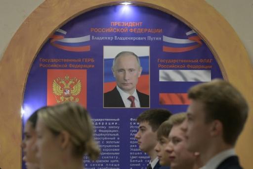 Des élèves d'un lycée font la file pour chanter l'hymne national russe lors de l'ouverture du scrutin dans un bureau de vote installé dans l'enceinte du lycée, à l'occasion des élections législatives russes à Donetsk, dans l'est de l'Ukraine sous contrôle russe, le 18 septembre 2026 — STRINGER / AFP