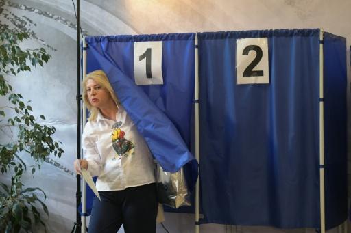 Une femme sort d'un isoloir après avoir voté aux élections législatives russes dans un bureau de vote de Donetsk, dans l'est de l'Ukraine sous contrôle russe, le 18 septembre 2026 — STRINGER / AFP