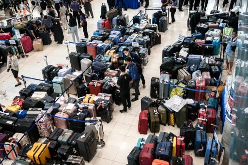 Passenger baggage from Thai Airways flights crowded Suvarnabhumi airport in Bangkok after flooding disrupted the airline's ground services — - / AFP