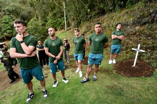 A Colombian who helped rescue survivors from the plane crash that wiped out the Brazilian football team Chapecoense in 2016 points to pictures of the victims — Jaime SALDARRIAGA / AFP