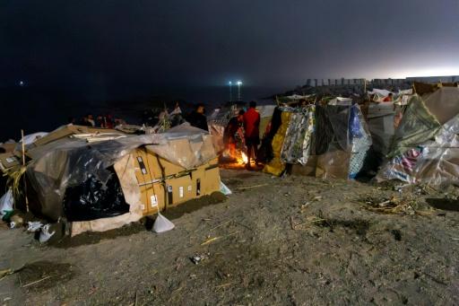 Unos migrantes encienden una fogata el 1 de septiembre de 2026 en la playa de El Trampolín de la ciudad española de Ceuta — Antonio Sempere / AFP