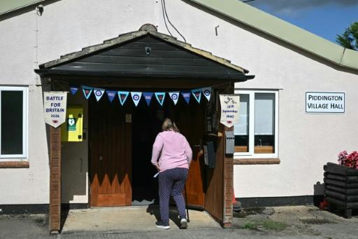 A local resident arrives to vote — JUSTIN TALLIS / AFP
