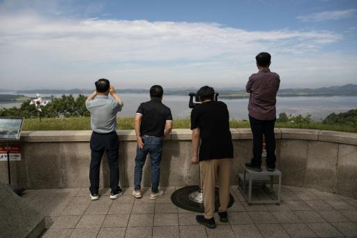 Visitors look towards North Korea, which has worked to seal off links to the outside world — Lillian SUWANRUMPHA / AFP