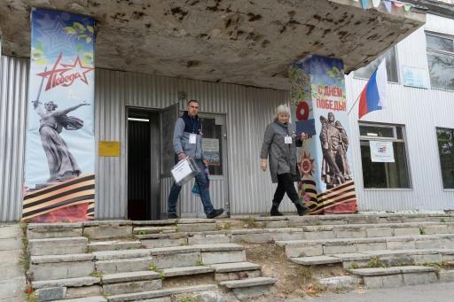 Miembros de la comisión electoral salen de un punto de votación para las elecciones parlamentarias de Rusia en Kudinovo, unos 140 km al suroeste de Moscú, el 20 de septiembre de 2026 — Andrey BORODULIN / AFP