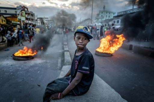 Image du photographe Luis Tato montrant un enfant assistant à des affrontements entre manifestants et forces de l'ordre lors du mouvement de la Gen Z malgache, à Antananarivo le 9 octobre 2025 — Luis TATO / AFP