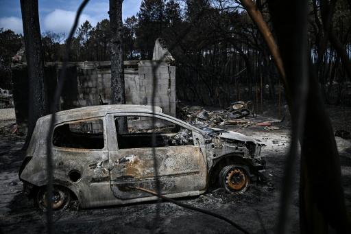Une voiture calcinée garée devant une maison incendiée au Porge, dans le sud-ouest de la France, le 3 août 2026 — Christophe ARCHAMBAULT / AFP