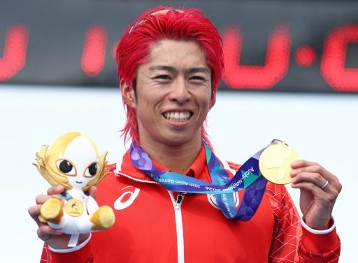 Japan's Takumi Hojo holds the first gold medal of the Asian Games after winning the men's individual triathlon in Gamagori city near Nagoya — JIJI PRESS / AFP