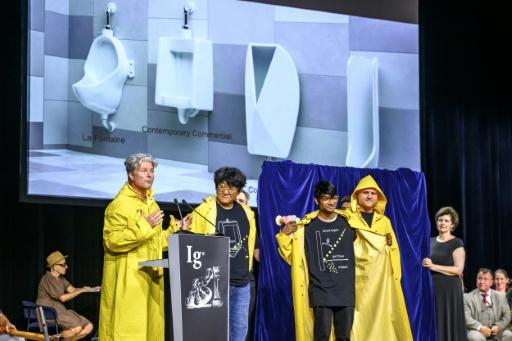 Urinal researchers wore yellow raincoats to collect their award for studying splashback — Fabrice COFFRINI / AFP