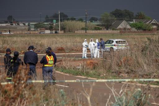 Des experts médico-légaux et des policiers travaillent sur la scène du crime où le corps d'une femme a été découvert, à Boksburg (Afrique du Sud), le 17 septembre 2026 — EMMANUEL CROSET / AFP