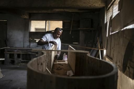 Daniel Oblie Mensah, 54, popularly known as 'Hello', designs a guitar-shaped coffin for a deceased musician at his workshop — OLYMPIA DE MAISMONT / AFP