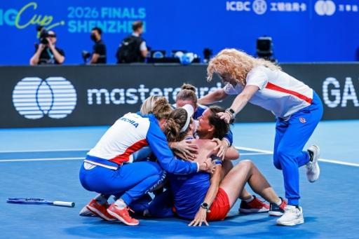 Linda Noskova (front 2L) is mobbed by her team-mates after clinching the winning point for the Czechs — - / AFP