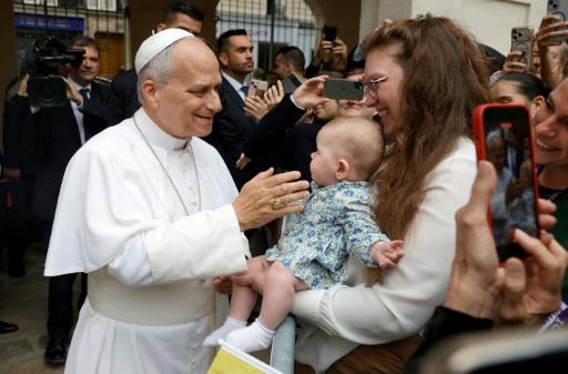 Parents arrived with pushchairs and held children on their shoulders as crowds hoped to catch a glimpse of the pontiff — GEOFFROY VAN DER HASSELT / AFP