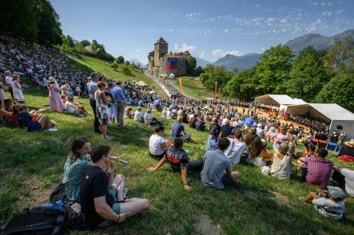 People gather on the slopes by Vaduz Castle during Liechtenstein National Day celebrations on August 15 — Fabrice COFFRINI / AFP