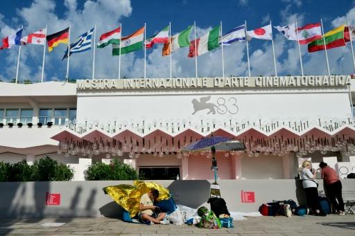 Des festivaliers campent sur le Lido devant le tapis rouge de la Mostra de Venise, en Italie, le 1er septembre 2026 — Stefano RELLANDINI / AFP