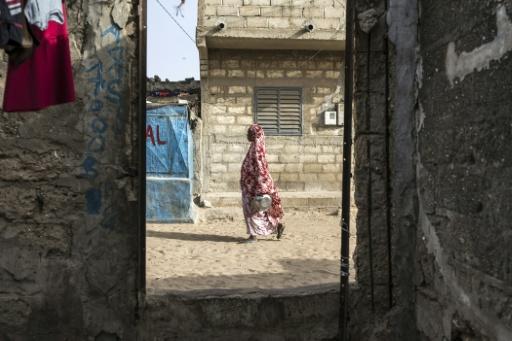 (ARCHIVES) Une femme marche dans une rue du quartier Tefees à Mbour, au Sénégal, le 9 mars 2026 — PATRICK MEINHARDT / AFP