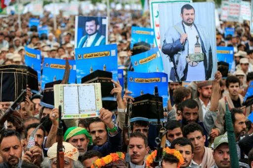 Supporters of the Houthis brandish weapons and hold up placards showing the Kaaba and reading "For it, we willingly offer our souls" during a protest against Saudi Arabia's recent accusation that the Houthis fired at the holy city of Mecca — Mohammed HUWAIS / AFP
