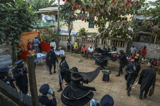 The action takes place in an open-air courtyard surrounded by people's homes — Daniel BELOUMOU OLOMO / AFP