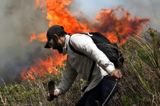 Un voluntario trabaja para extinguir un incendio forestal en el cerro de San Marcos, en el municipio de Villa de Leyva, departamento de Boyacá, Colombia, el 20 de septiembre, — LUIS LIZARAZO / AFP
