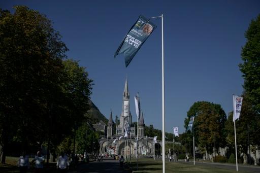 Une banderole annonçant la visite du pape Léon, devant la basilique Notre-Dame du Rosaire, à Lourdes, le 15 septembre 2026 — Ed JONES / AFP