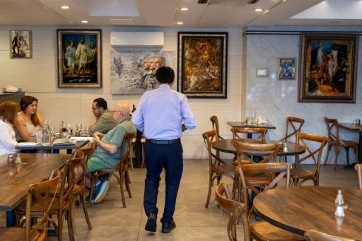 Customers dine beneath portraits depicting members of Iran's former royal family at Amoo's, a family-owned Persian restaurant in McLean, Virginia — Amid FARAHI / AFP