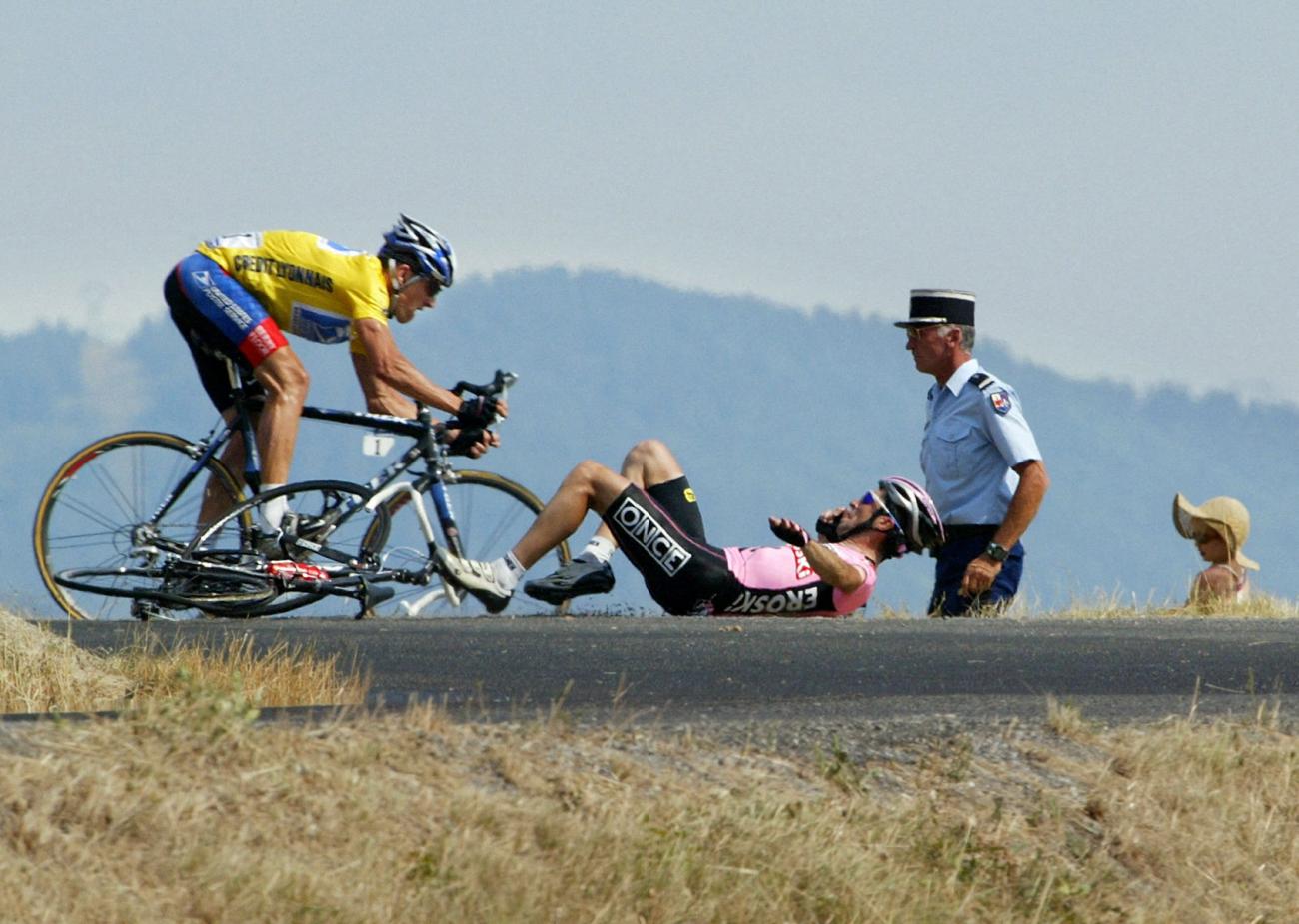 Lance Armstrong avoids Joseba Beloki who fell down at the end of the ninth stage of the 90th Tour de France cycling race