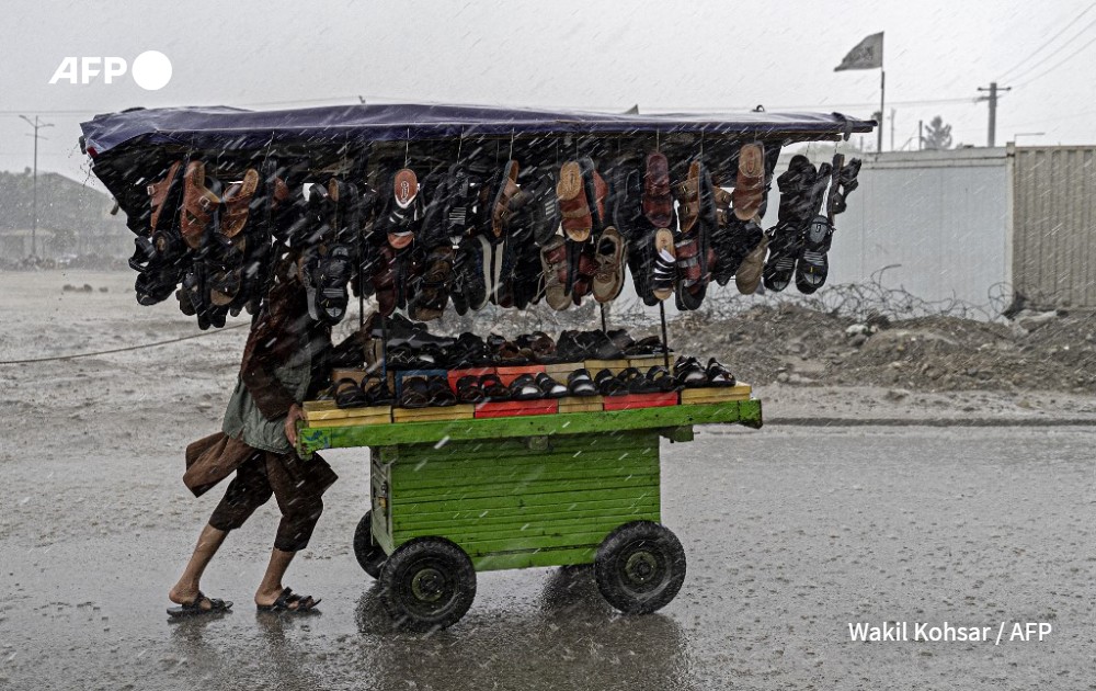 AFP photo by Wakil Kohsar - An Afghan vendor under the rain