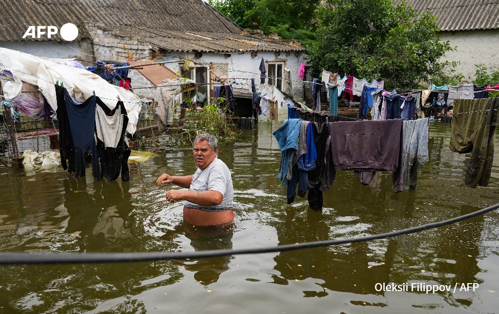 A local resident walks in flooded yard of his house