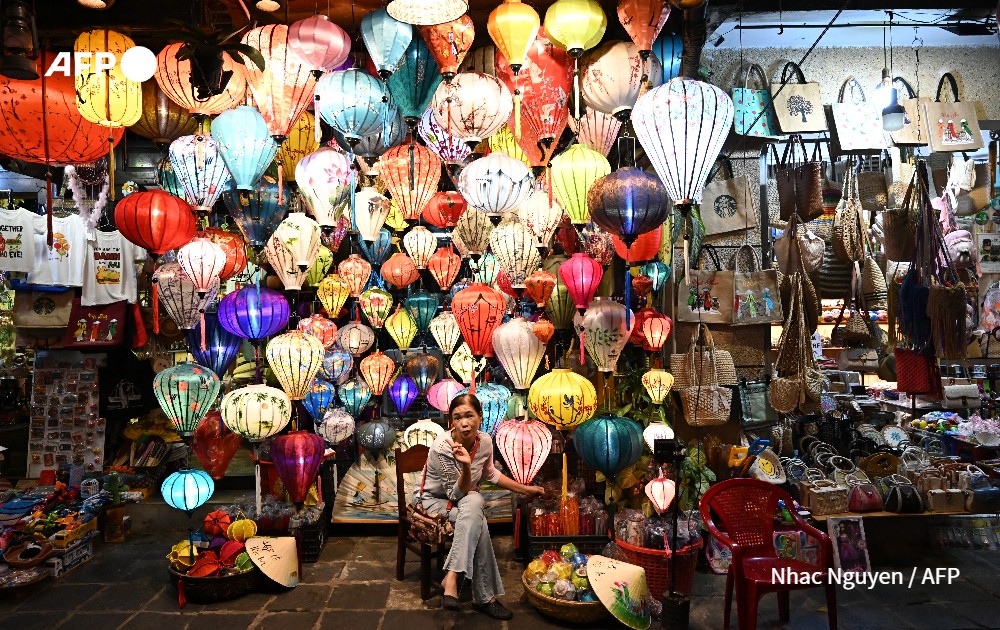 Woman waits for customers in front of her lantern shop